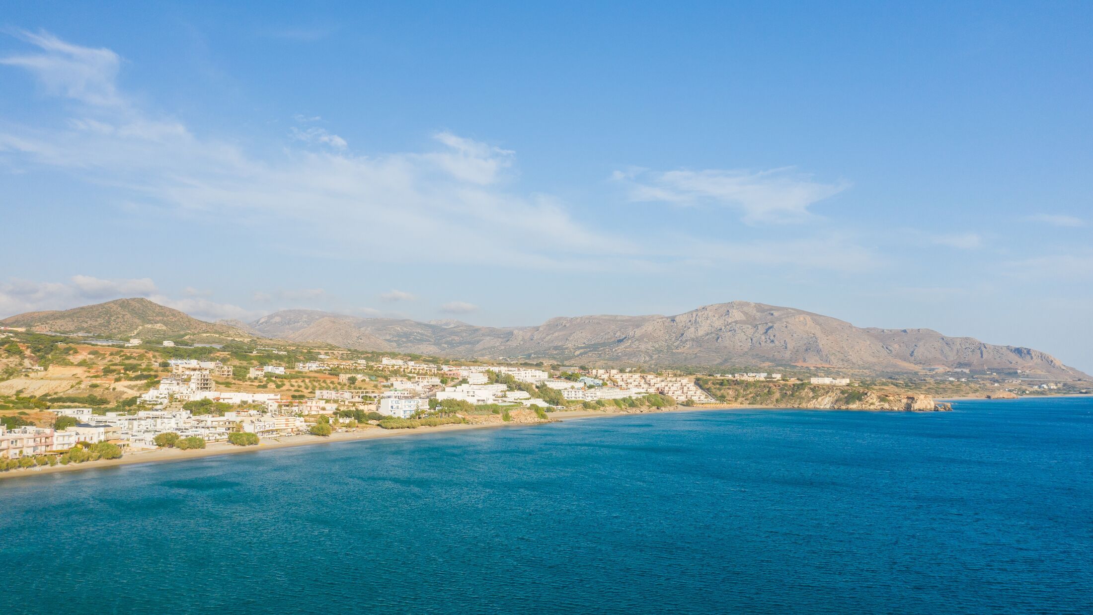 The paradise coast and the sandy beach at the foot of the mountains, in Europe, Greece, Crete, Analipsi, By the Mediterranean Sea, in summer, on a sunny day.