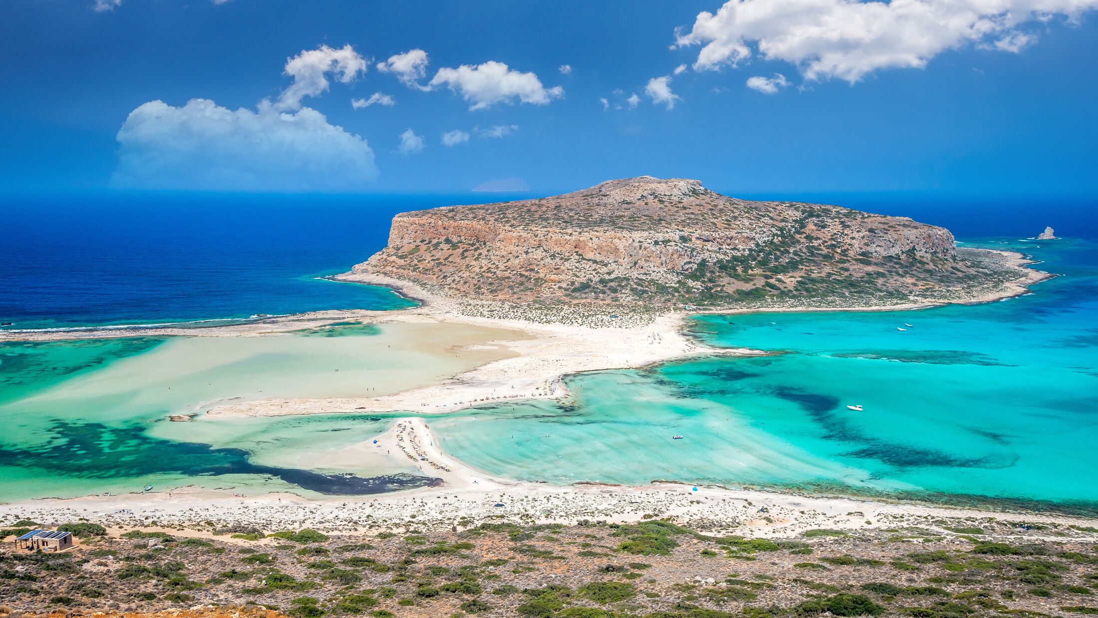 Balos lagoon on Crete island, Greece. Tourists relax and bath in crystal clear water of Balos beach.