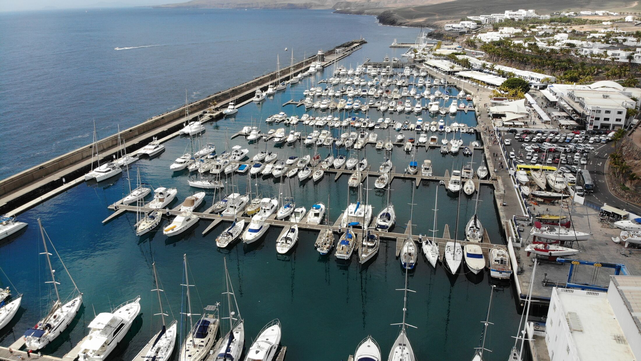 Aerial photo of the beautiful Boats and Boat Harbour Marina and pier taken in Lanzarote in Spain one of the Canary islands, showing all kinds of sailing boats in the calm ocean at Marina Puerto Calero